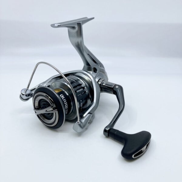 Silver fishing reel with black handle.