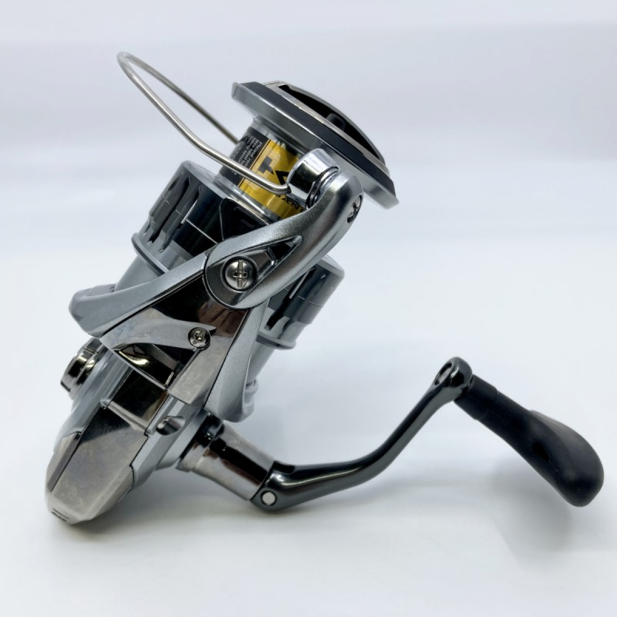 Silver fishing reel with handle and spool.