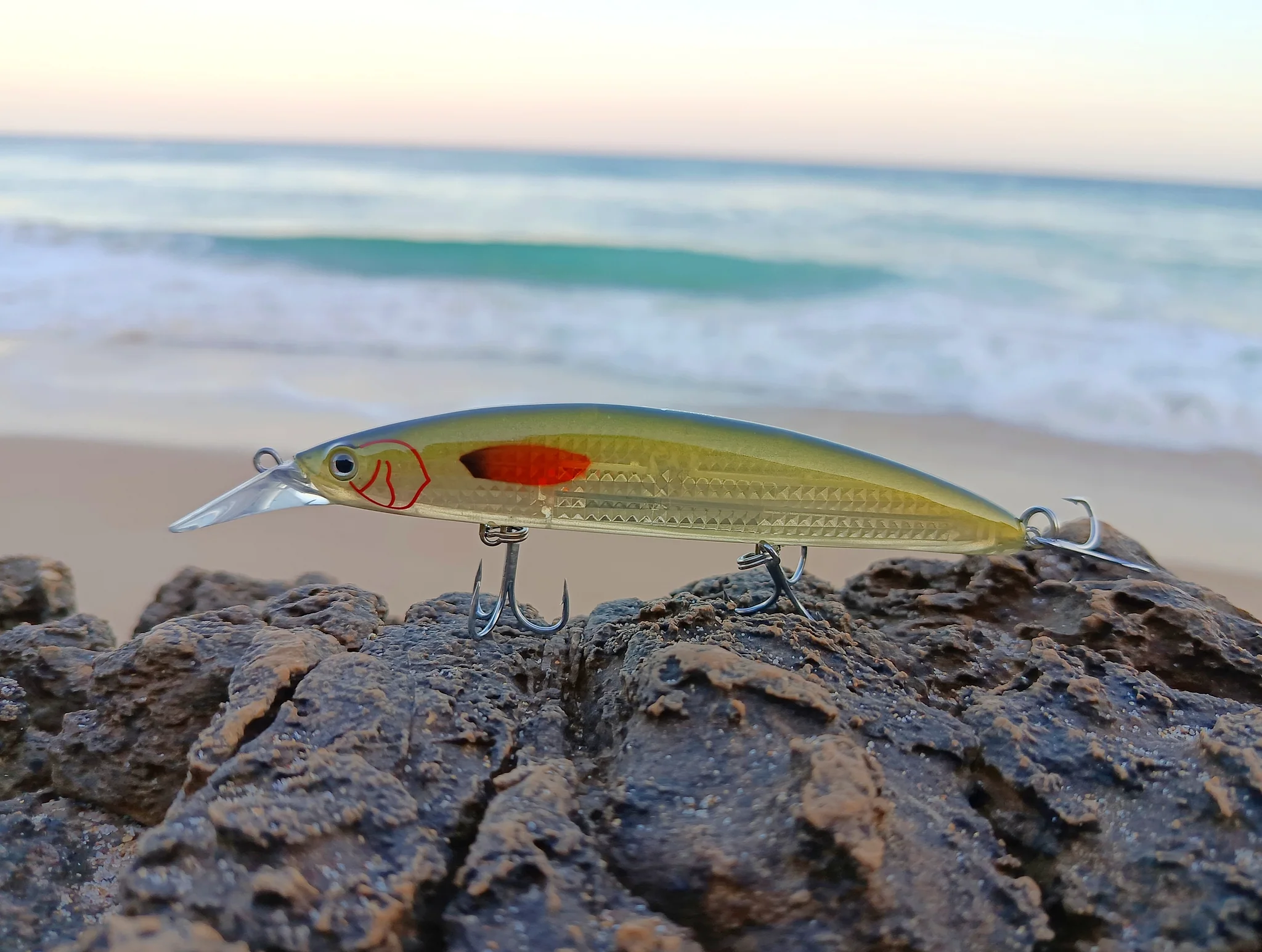 Fishing lure on rocky beach background