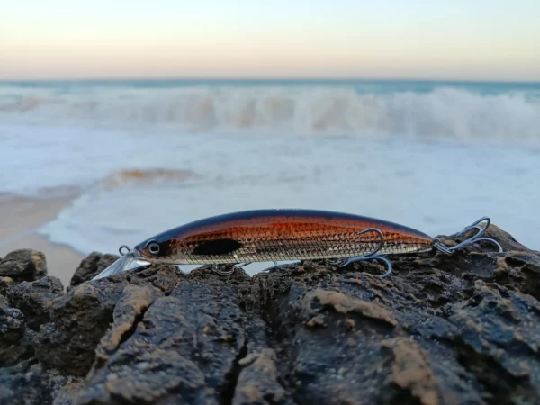 Fishing lure on rocks by seaside waves
