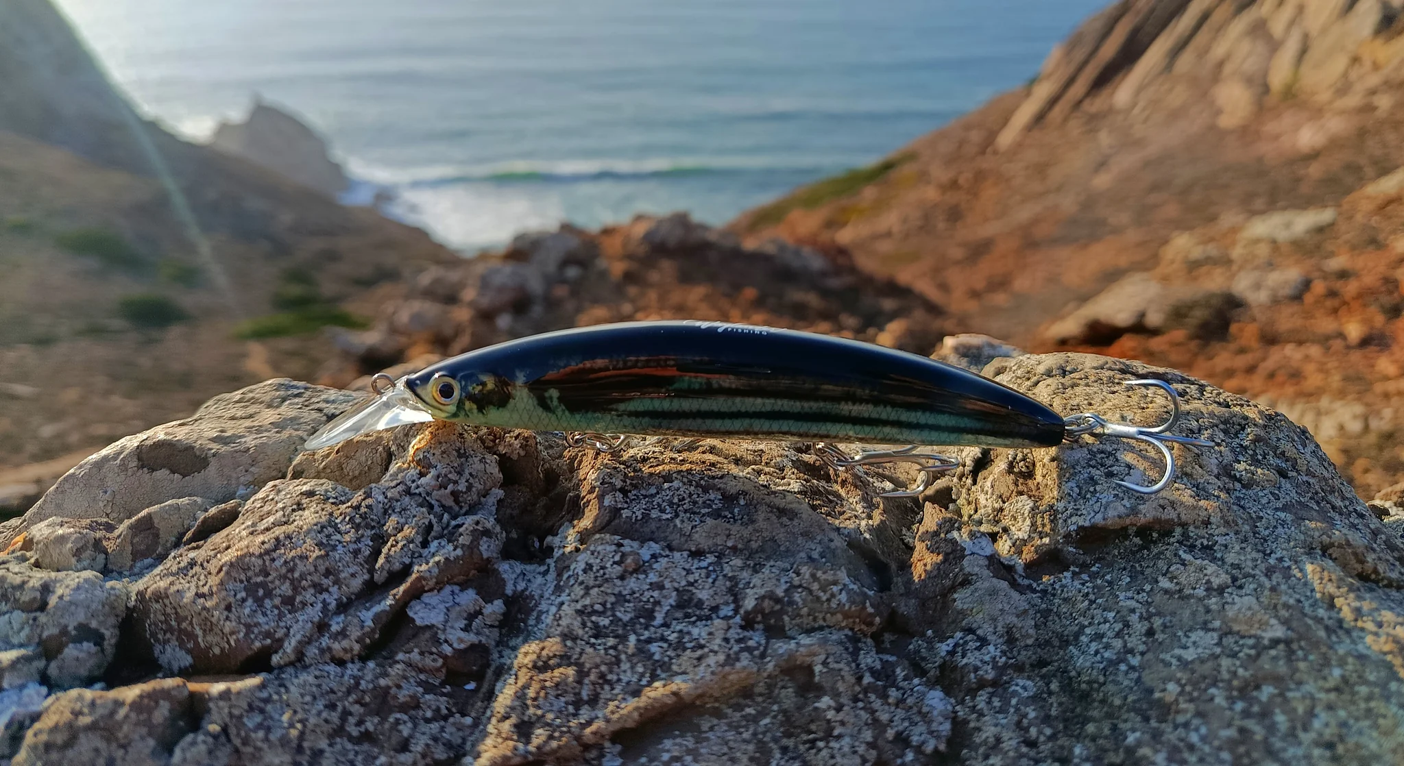 Fishing lure on rocky coastal terrain.