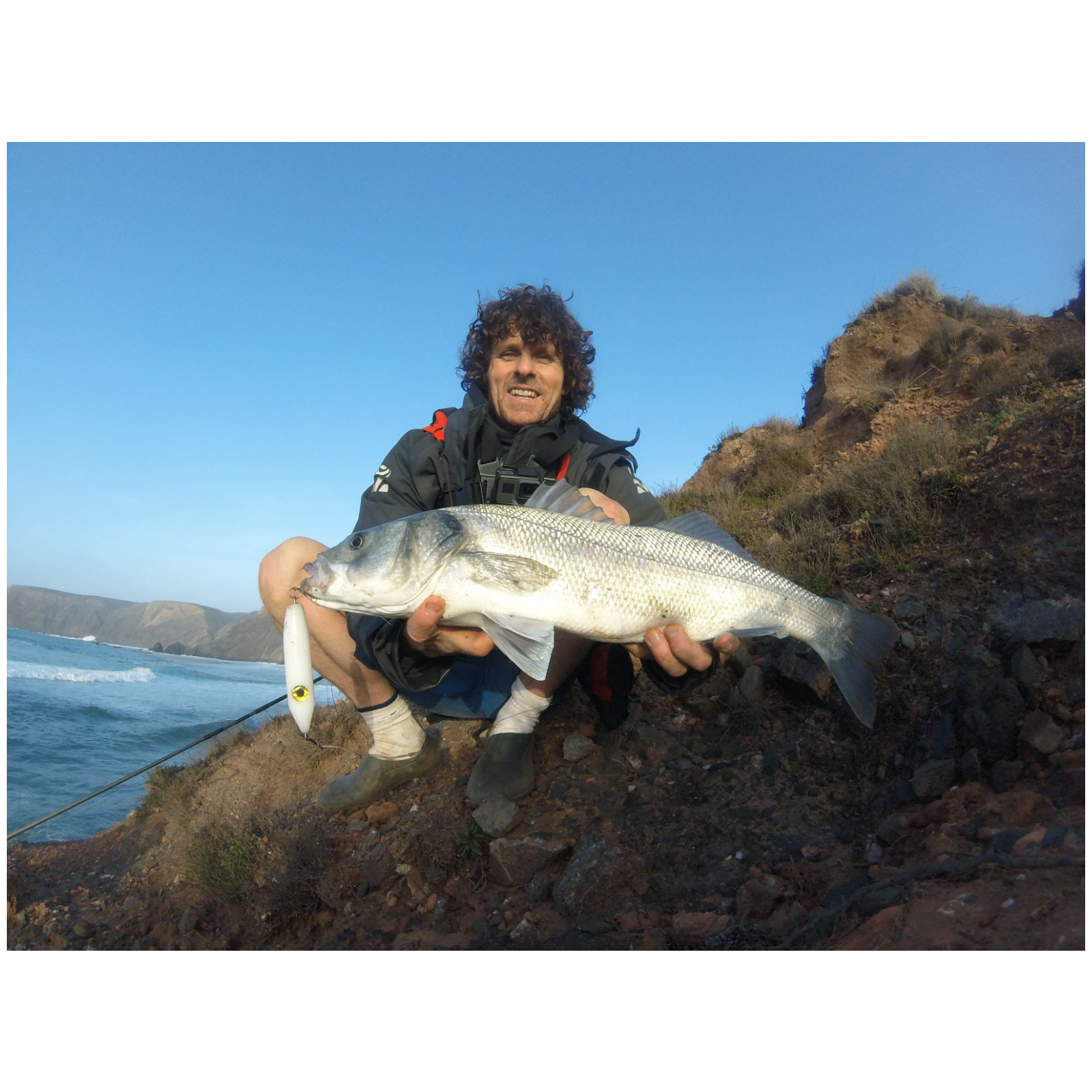 Man holding large fish by the sea