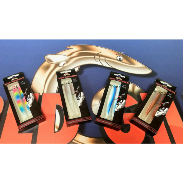 Four packaged Bass Assassins fishing lures before shark graphic